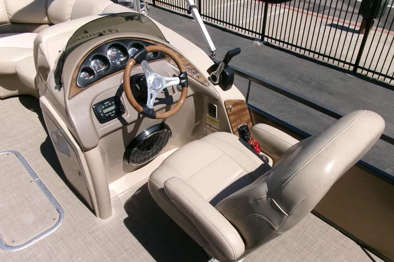 Slide: The Image of 2015 Manitou 25 SES Flip boat interior with steering wheel and control panel. - 12