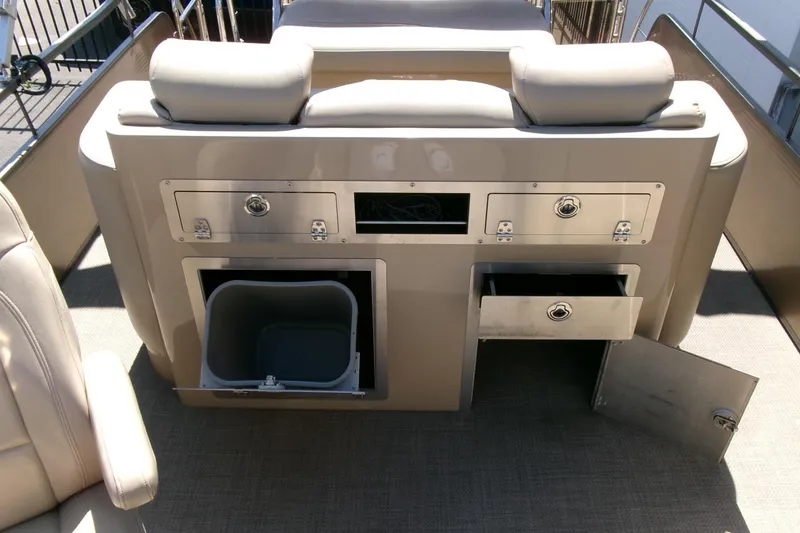 Slide: The Image of 2015 Manitou 25 SES Flip boat interior with storage compartments and seating. - 15