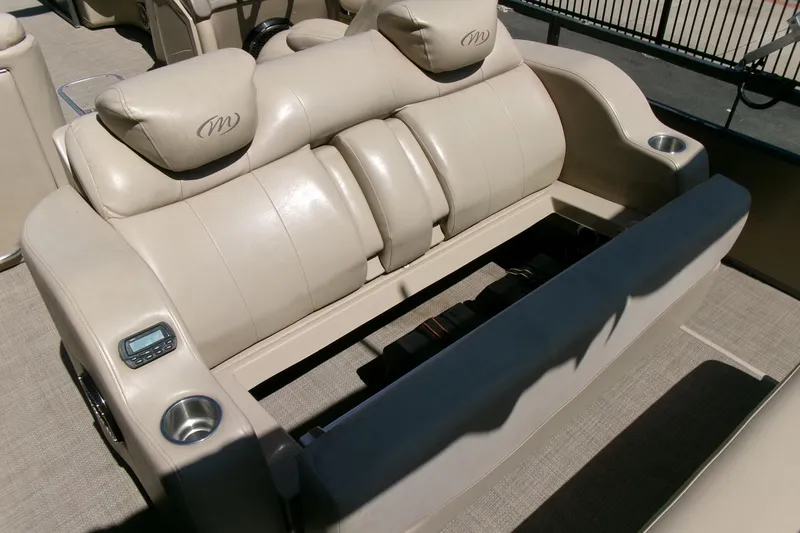 Slide: The Image of Luxurious seating on 2015 Manitou 25 SES Flip pontoon boat with cup holders and controls. - 18