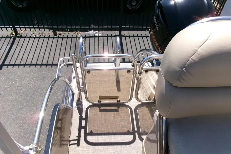 Slide: The Image of 2015 Manitou 25 SES Flip boat with beige seating and stainless steel railing. - 25