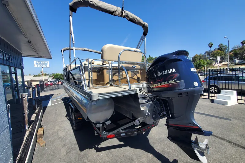Slide: The Image of 2015 Manitou 25 SES Flip pontoon boat with Yamaha outboard motor in a marina setting. - 3