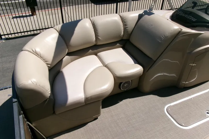 Slide: The Image of Luxurious seating on a 2015 Manitou 25 SES Flip pontoon boat, featuring plush beige upholstery. - 6