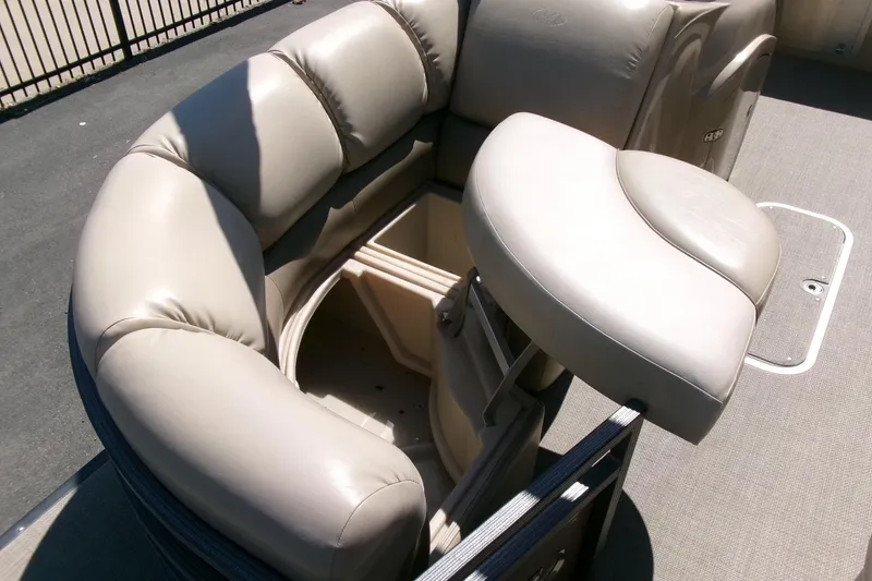 Slide: The Image of 2015 Manitou 25 SES Flip boat with beige cushioned seating and storage compartment. - 7