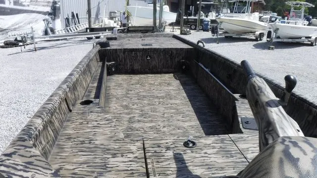 Slide: The Image of 2026 Excel Boats Eclipse 17’ with camouflage pattern at a boatyard. - 6