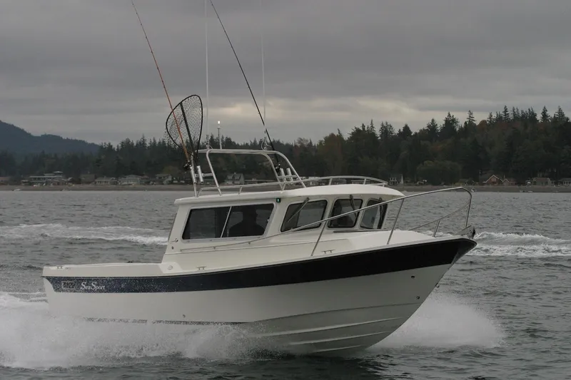 Slide: The Image of 2026 Sea Sport XL 2400 boat cruising on a lake with forested shoreline. - 11