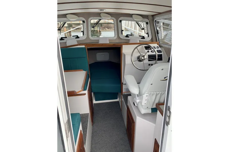 Slide: The Image of Interior of 2026 Sea Sport XL 2400 boat with helm, seating, and cabin area. - 6