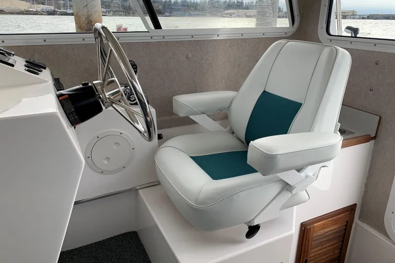 Slide: The Image of Captain's chair and steering wheel inside 2026 Sea Sport XL 2400 boat cabin. - 8