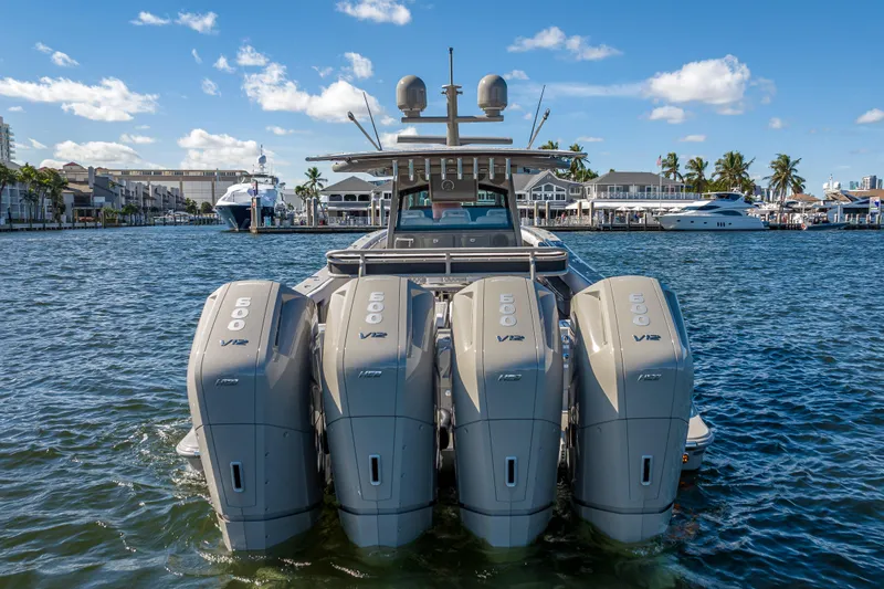 Slide: The Image of 2024 HCB 53 Suenos boat with four powerful V12 engines on a sunny waterfront. - 12
