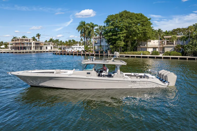 Slide: The Image of 2024 HCB 53 Suenos luxury boat cruising on a scenic waterfront with palm trees. - 16