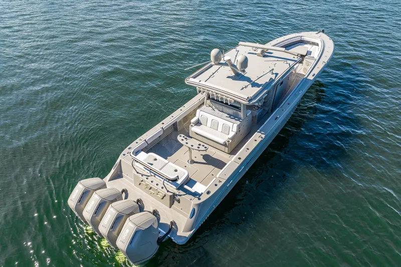 Slide: The Image of 2024 HCB 53 Suenos luxury boat on open water, featuring four powerful outboard engines. - 21