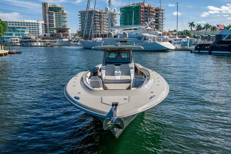 Slide: The Image of 2024 HCB 53 Suenos luxury boat docked in a marina with cityscape background. - 22