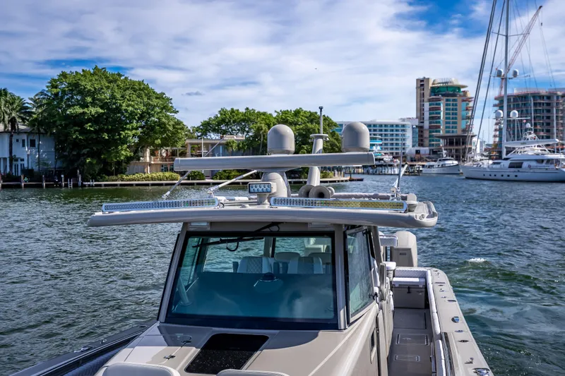 Slide: The Image of 2024 HCB 53 Suenos boat docked in a marina with cityscape background. - 41