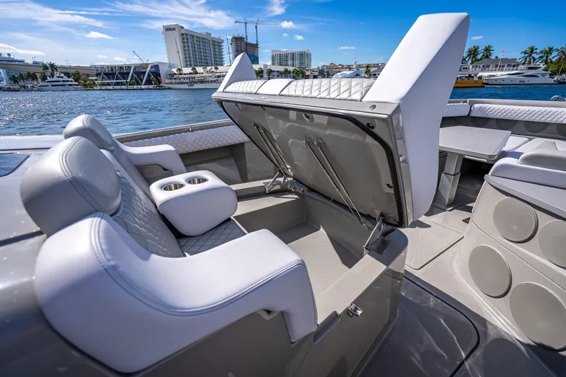 Slide: The Image of 2024 HCB 53 Suenos boat interior with open storage, luxurious seating, and waterfront view. - 43