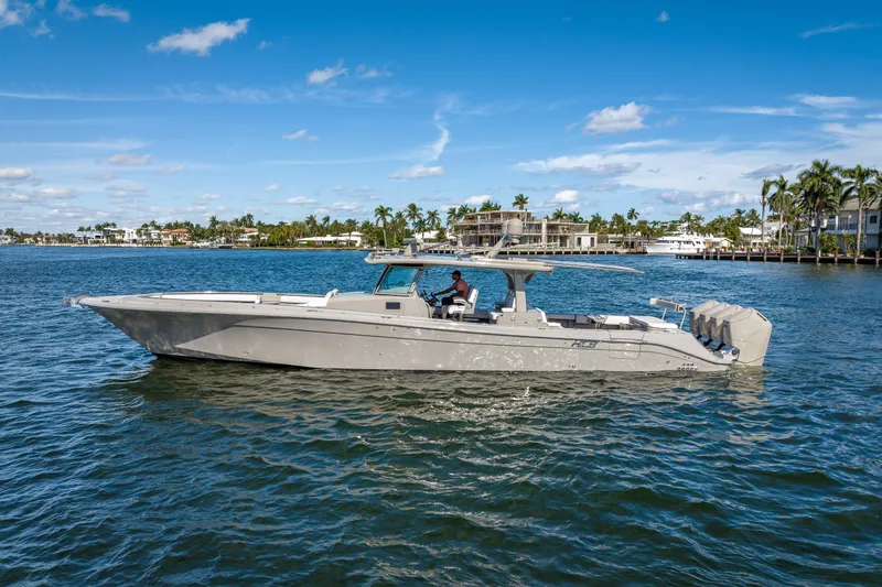 Slide: The Image of 2024 HCB 53 Suenos boat cruising on a sunny day, surrounded by waterfront homes. - 5