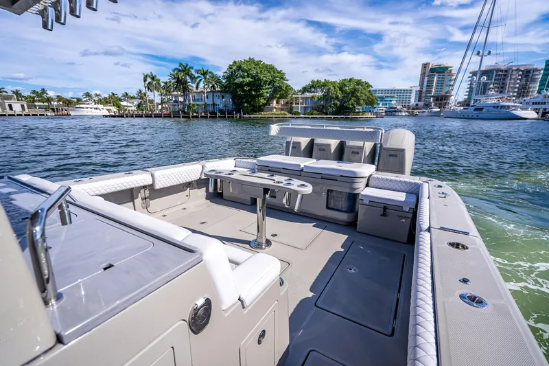 Slide: The Image of 2024 HCB 53 Suenos luxury boat with spacious deck and seating, docked in a scenic marina. - 59