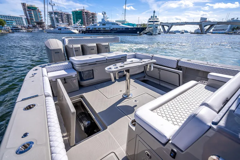 Slide: The Image of 2024 HCB 53 Suenos luxury boat interior with seating and table, docked in a marina. - 60