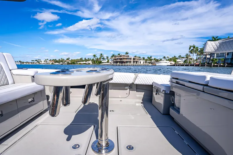 Slide: The Image of 2024 HCB 53 Suenos boat interior with seating and table, overlooking waterfront homes. - 61