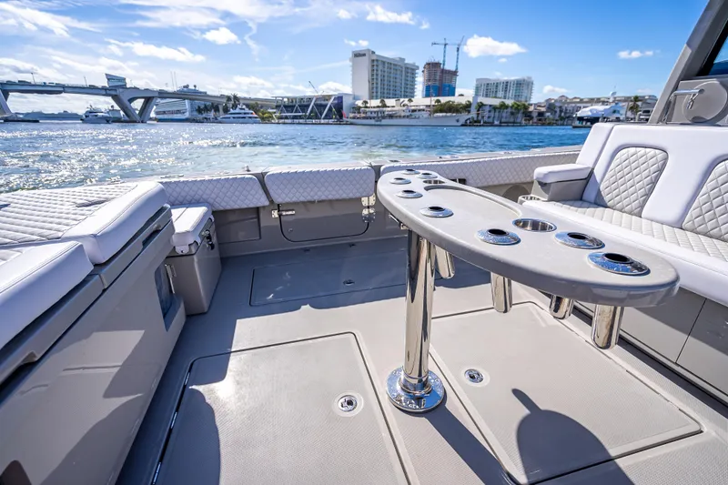 Slide: The Image of 2024 HCB 53 Suenos luxury boat interior with seating and table, docked by waterfront. - 62