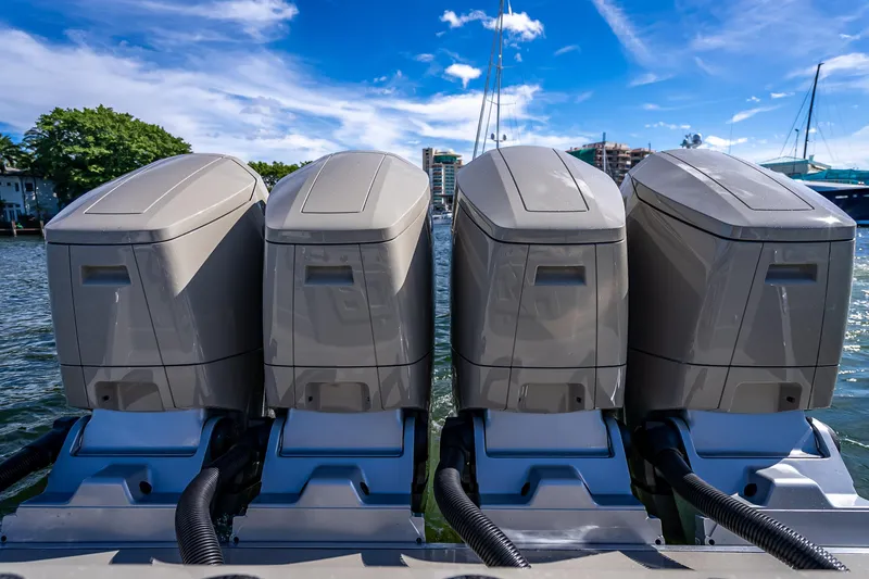 Slide: The Image of Four powerful outboard engines on a 2024 HCB 53 Suenos boat, docked by the water. - 71