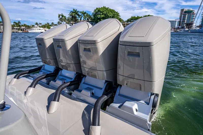 Slide: The Image of Four powerful outboard engines on a 2024 HCB 53 Suenos boat, docked by the water. - 73