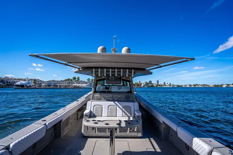 Slide: The Image of 2024 HCB 53 Suenos boat on water, clear blue sky, luxury seating, coastal cityscape. - 76