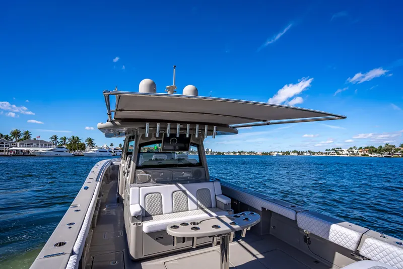 Slide: The Image of 2024 HCB 53 Suenos boat on water, clear blue sky, luxury seating, coastal view. - 77