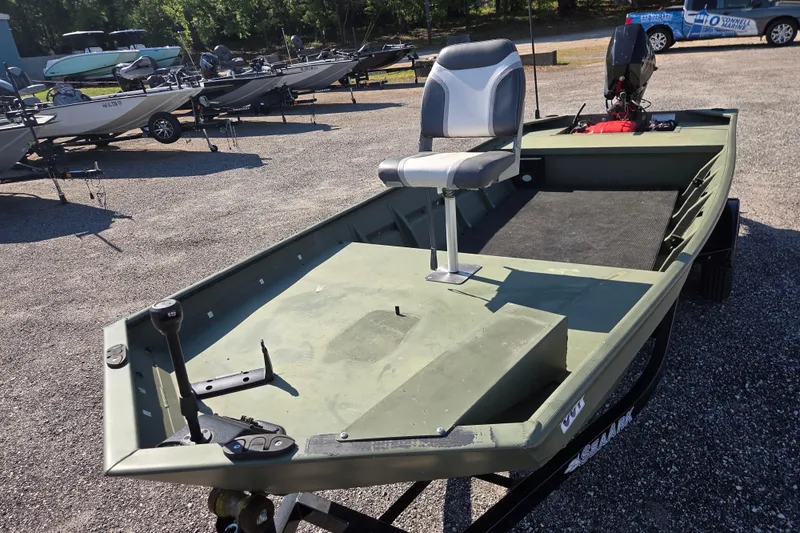 Slide: The Image of 2023 SeaArk 1648 MV boat with seating, parked on a trailer in a lot. - 10