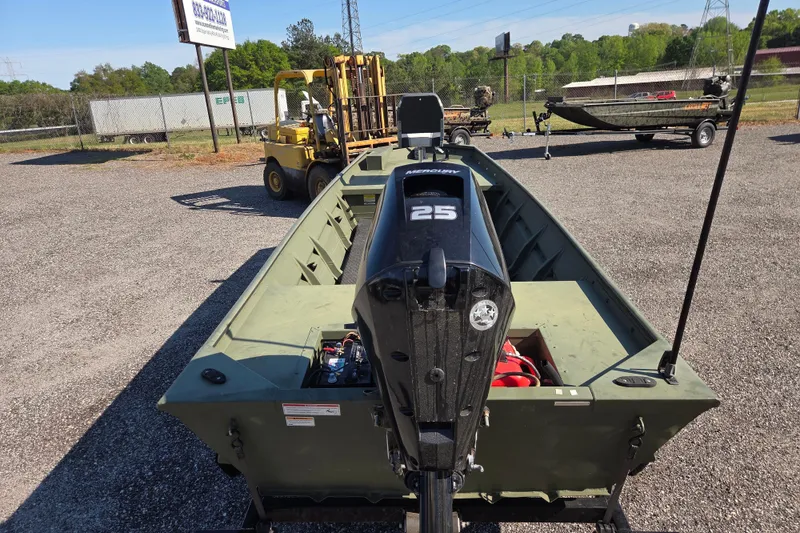 Slide: The Image of 2023 SeaArk 1648 MV boat with Mercury 25 HP outboard motor, parked outdoors. - 2