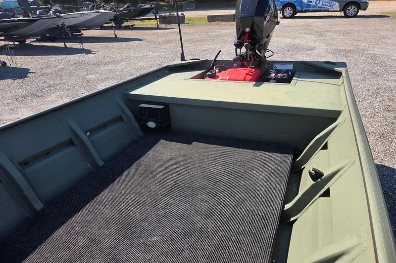 Slide: The Image of 2023 SeaArk 1648 MV boat interior with motor, parked on gravel lot. - 9