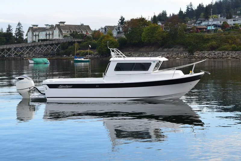 The Image of 2026 Sea Sport Kenai 2600 boat on calm water near a scenic shoreline. - 1
