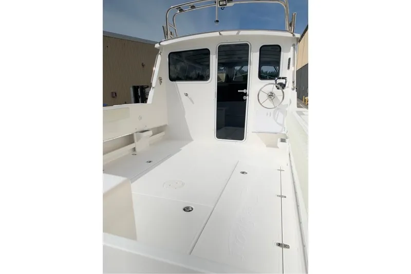 Slide: The Image of 2026 Sea Sport Kenai 2600 boat deck with steering wheel and cabin entrance. - 3