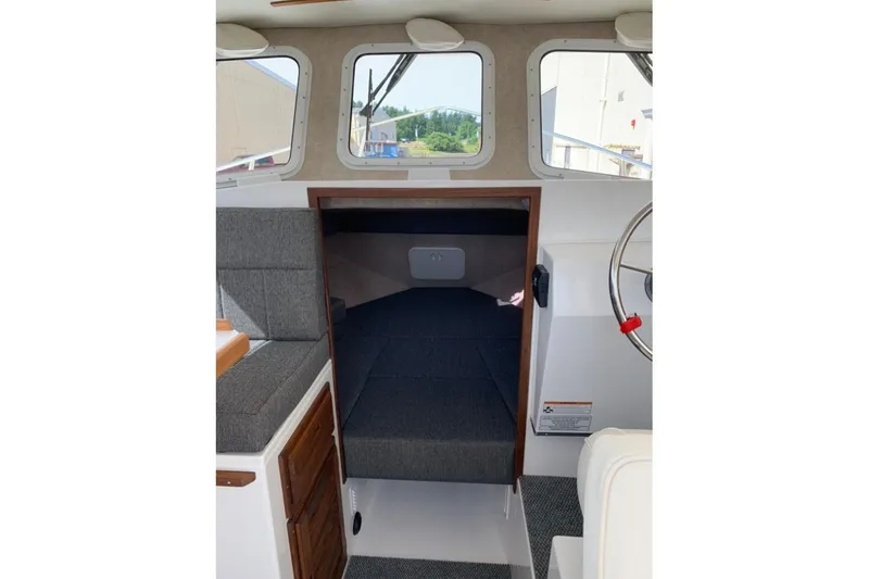 Slide: The Image of Interior cabin of 2026 Sea Sport Kenai 2600 boat, featuring seating and helm. - 8