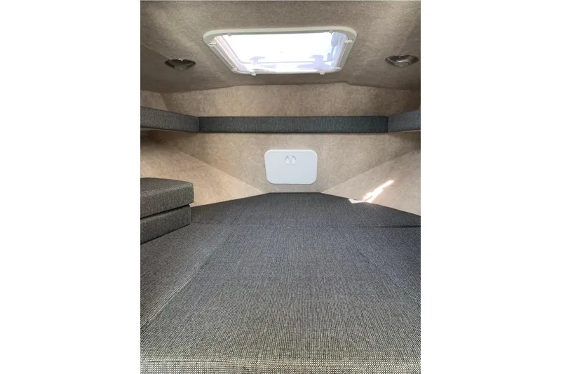 Slide: The Image of Interior cabin of 2026 Sea Sport Kenai 2600 boat, featuring gray upholstery and overhead hatch. - 9
