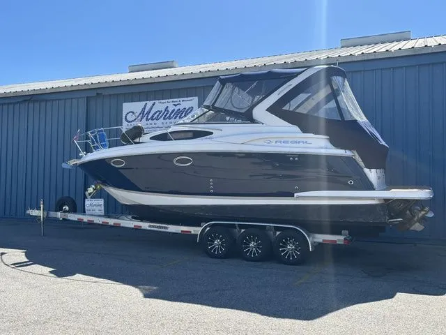 Slide: The Image of 2014 Regal Express Cruiser 30 on trailer in front of blue building. - 3