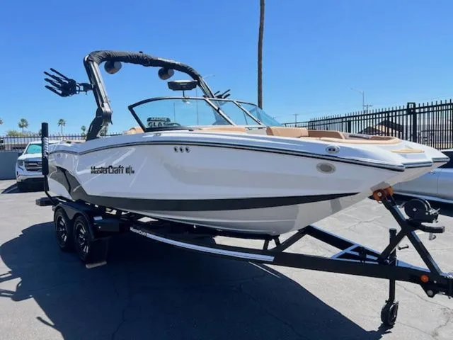 Slide: The Image of 2026 MasterCraft NXT22 boat on trailer outdoors. - 4