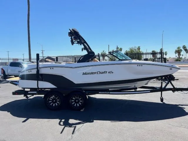 Slide: The Image of 2026 MasterCraft NXT22 boat on trailer outdoors. - 5