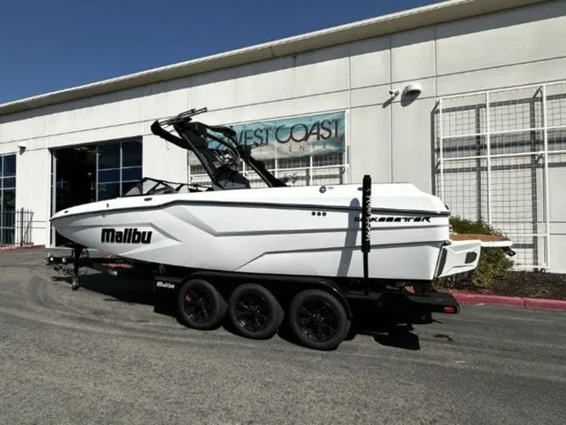 Slide: The Image of 2026 Malibu Wakesetter 24 MXZ boat on trailer outside building. - 3