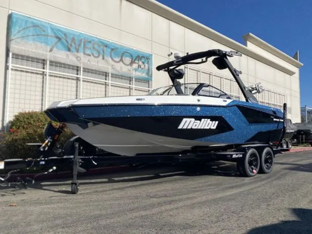 The Image of 2026 Malibu Wakesetter 23 MXZ boat on trailer outside building. - 1