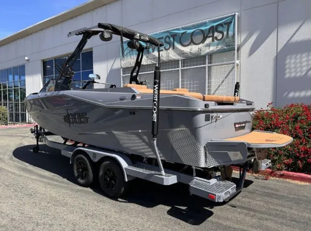 Slide: The Image of 2026 Axis Wake Research T235 boat on trailer outside building. - 3