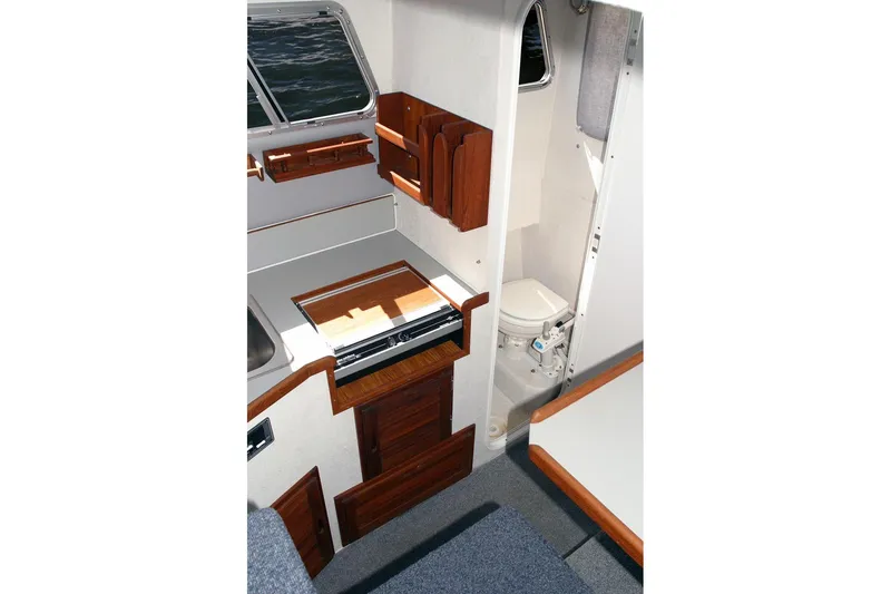 Slide: The Image of Interior of 2026 Sea N Sport Alaskan Pilot 2600, featuring compact kitchen and bathroom. - 5