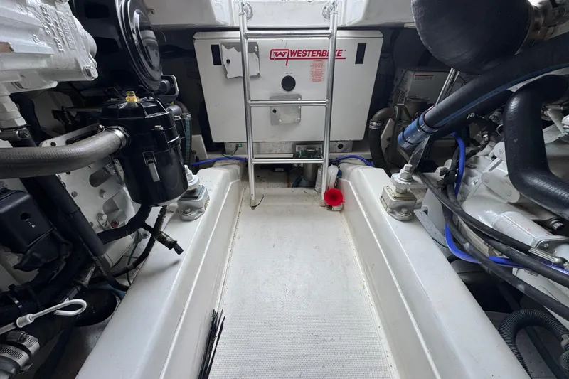 Slide: The Image of Engine room of 2009 Ocean Yachts 42 Super Sport, featuring mechanical components and ladder. - 13