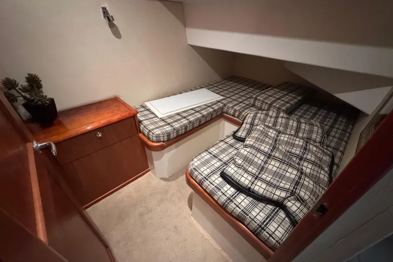 Slide: The Image of Cozy cabin interior of 2009 Ocean Yachts 42 Super Sport with plaid bedding and wooden cabinetry. - 6
