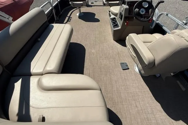Slide: The Image of 2024 Sun Tracker Bass Buggy 16 XL pontoon boat interior with beige seating and steering console. - 5