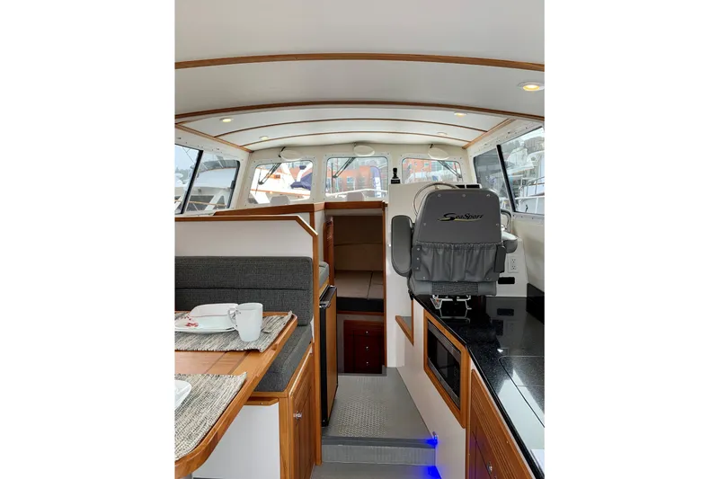 Slide: The Image of Interior of 2026 Sea Sport Voyager 3000 boat, featuring modern seating and dining area. - 3