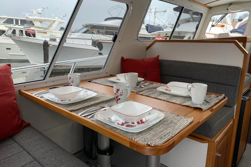 Slide: The Image of Interior of 2026 Sea Sport Voyager 3000 with dining setup and marina view. - 4