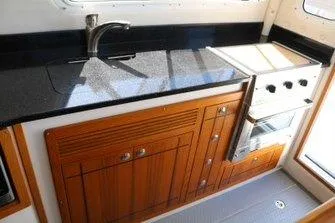 Slide: The Image of 2026 Sea Sport Voyager 3000 boat kitchen with wooden cabinetry and modern appliances. - 7