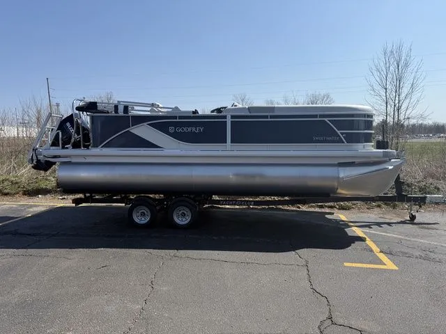 The Image of 2026 Sweetwater SW2086CPSE pontoon boat on trailer outdoors. - 1