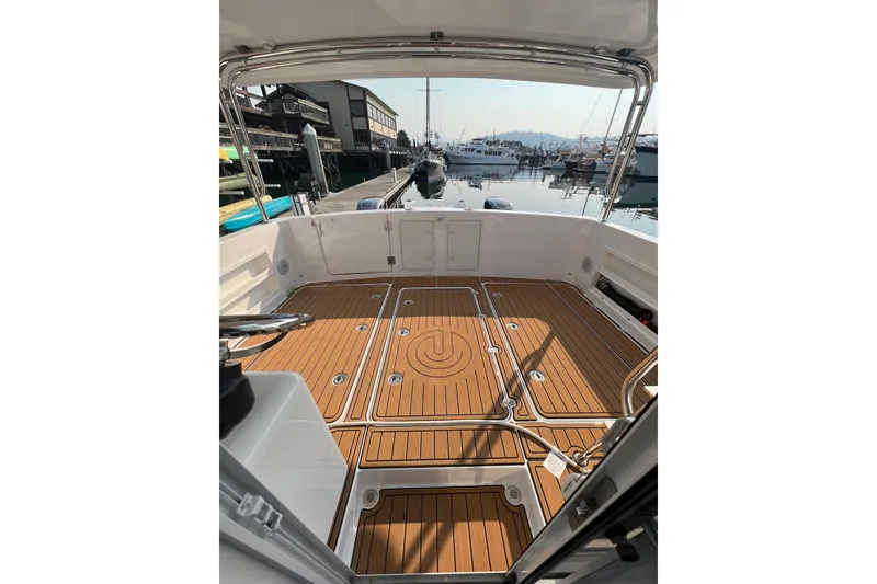 Slide: The Image of 2026 Sea Sport Pacific 3200 boat deck with wood finish, docked at marina. - 10