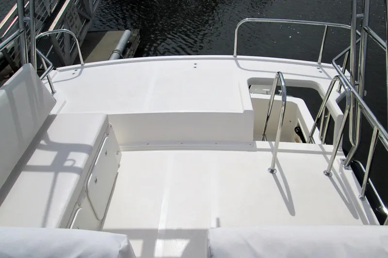 Slide: The Image of 2026 Sea Sport Pacific 3200 boat deck with seating and railing, docked by water. - 11