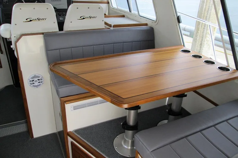 Slide: The Image of Interior of 2026 Sea Sport Pacific 3200 with wooden table and cushioned seating. - 13